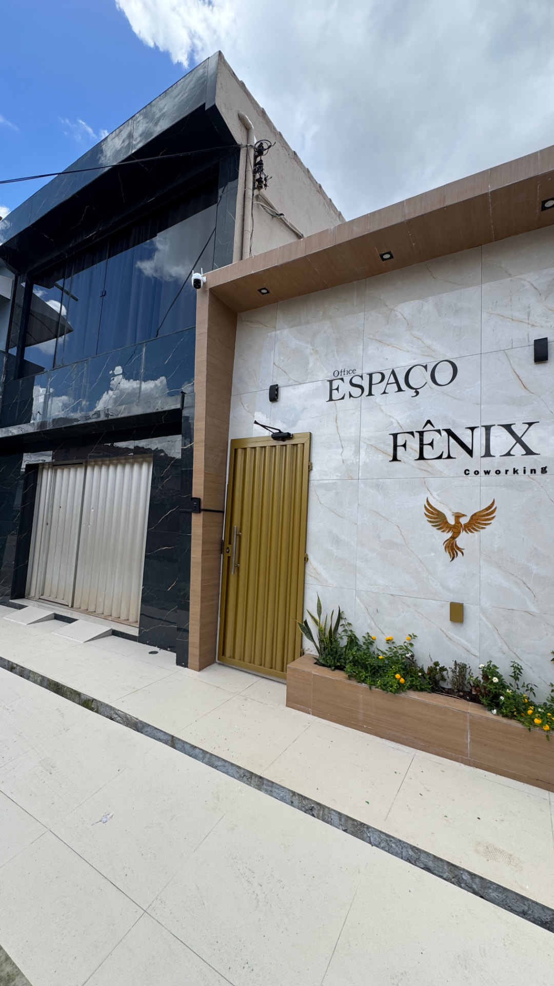 Fachada do Office Espaço Fênix Coworking com letreiro e logo em dourado