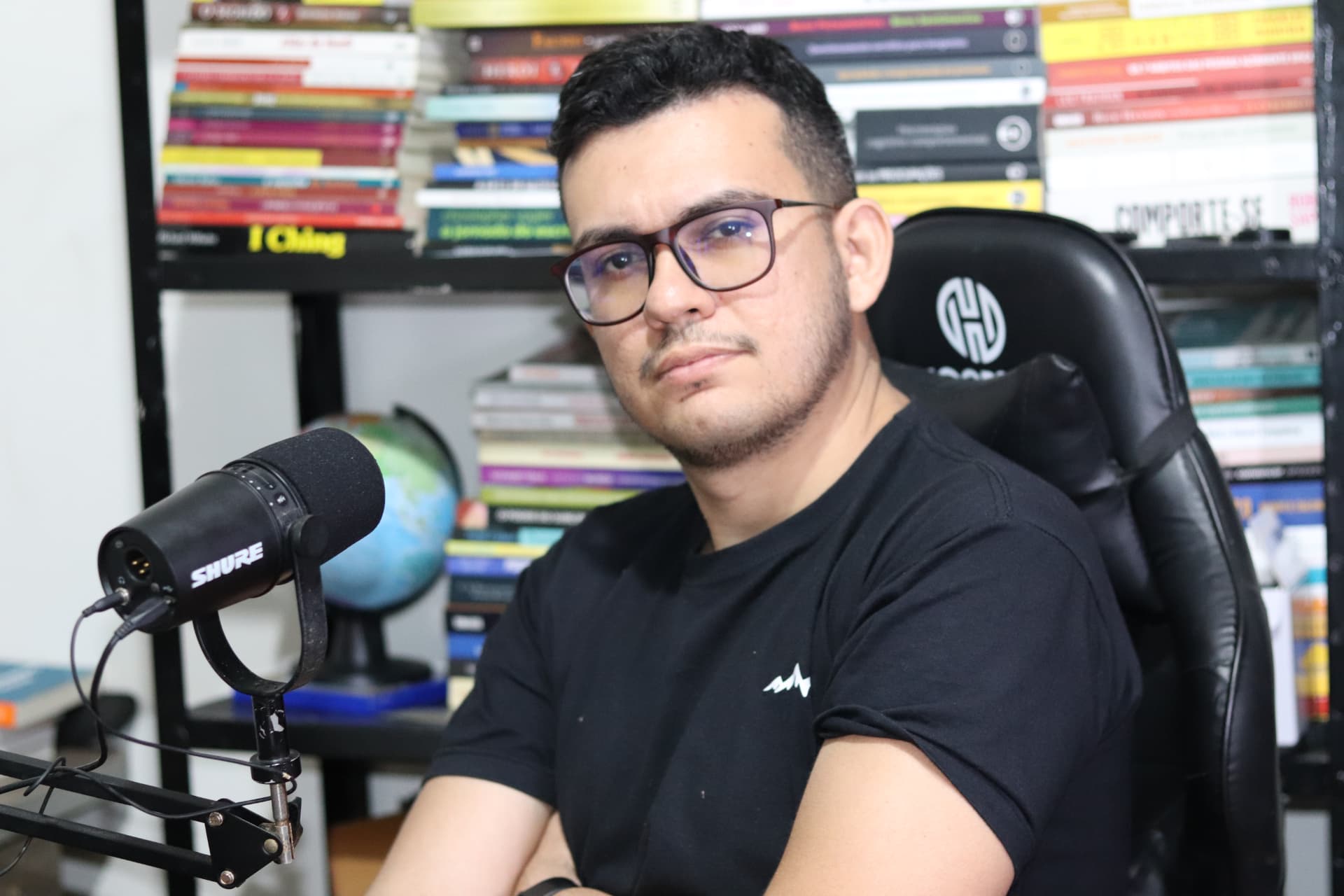 MSc. Luiz Sousa em seu estúdio, cercado de livros de psicologia
